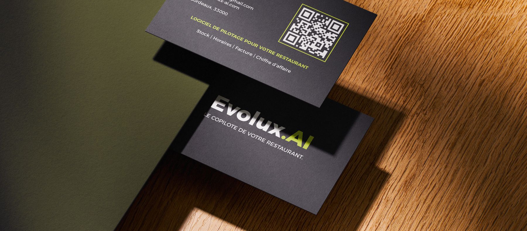 Carte de visite Evolux.AI posée sur une table en bois : logo, QR code et coordonnées de contact